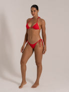 Front angle of red halter neck bikini set with textured fabric and cheeky coverage