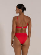 Model wearing red high-waisted textured bikini bottom from back view