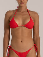 Front view of a woman wearing a red textured triangle bikini set with halter neck straps and adjustable side-tie bottoms, designed for a bold and flattering beach look.