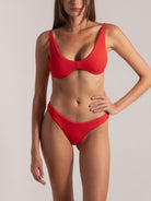 Woman wearing a red textured underwire bikini set, front view