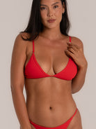 Close-up of woman wearing a red triangle bikini top with thin adjustable straps, showcasing a minimal and flattering swimwear design.