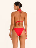 Back angle of red triangle bikini top with halter straps and minimal coverage.
