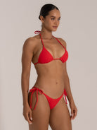 Model in red triangle bikini top viewed from side front showing flattering neckline