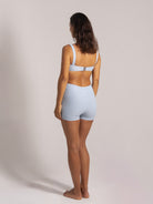 Back view of a woman wearing a ribbed light blue bikini top and matching high-waisted shorts