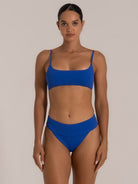 Front view of royal blue high waisted bikini bottom with wide waistband and matching bralette bikini top