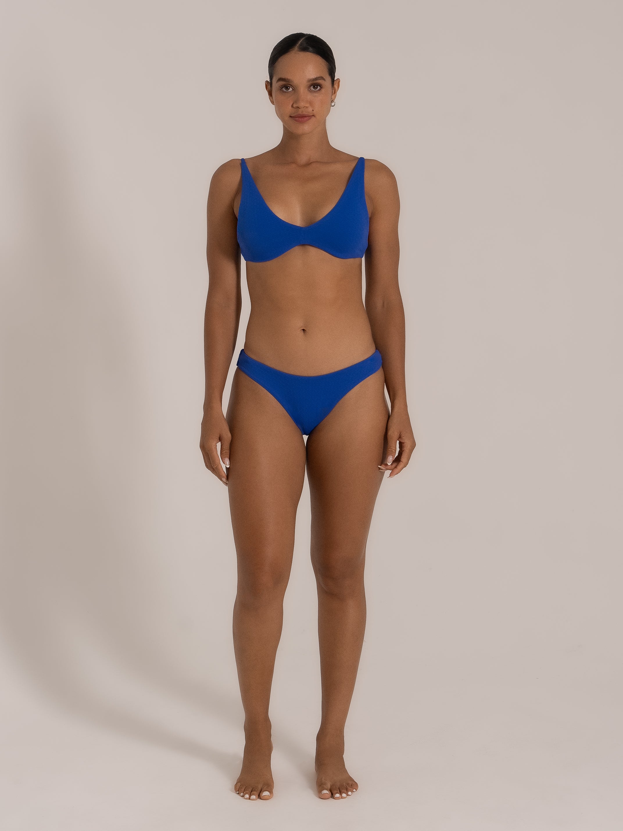 Front view of model in royal blue bikini set with scoop neck top and classic cut bottoms.