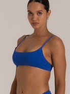 Side angle of royal blue bikini top showing scoop sides and textured fabric