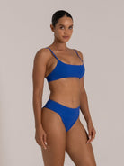 Model wearing royal blue square neck bikini top with minimal design