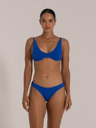 Woman in royal blue bikini featuring underwire support and textured fabric, front pose