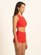 Front 45-degree view of the Ruby red boy short swim bottoms, demonstrating the comfortable and flattering fit of the high-waisted design with white piping.