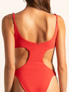 Close up back view of red textured cut out one piece swimsuit with high cut leg design.