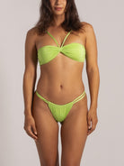 Front full-body view of model in shimmer lime green thong bikini bottom