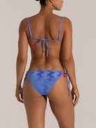 Angled view of shimmering blue tie bikini bottom with wavy texture