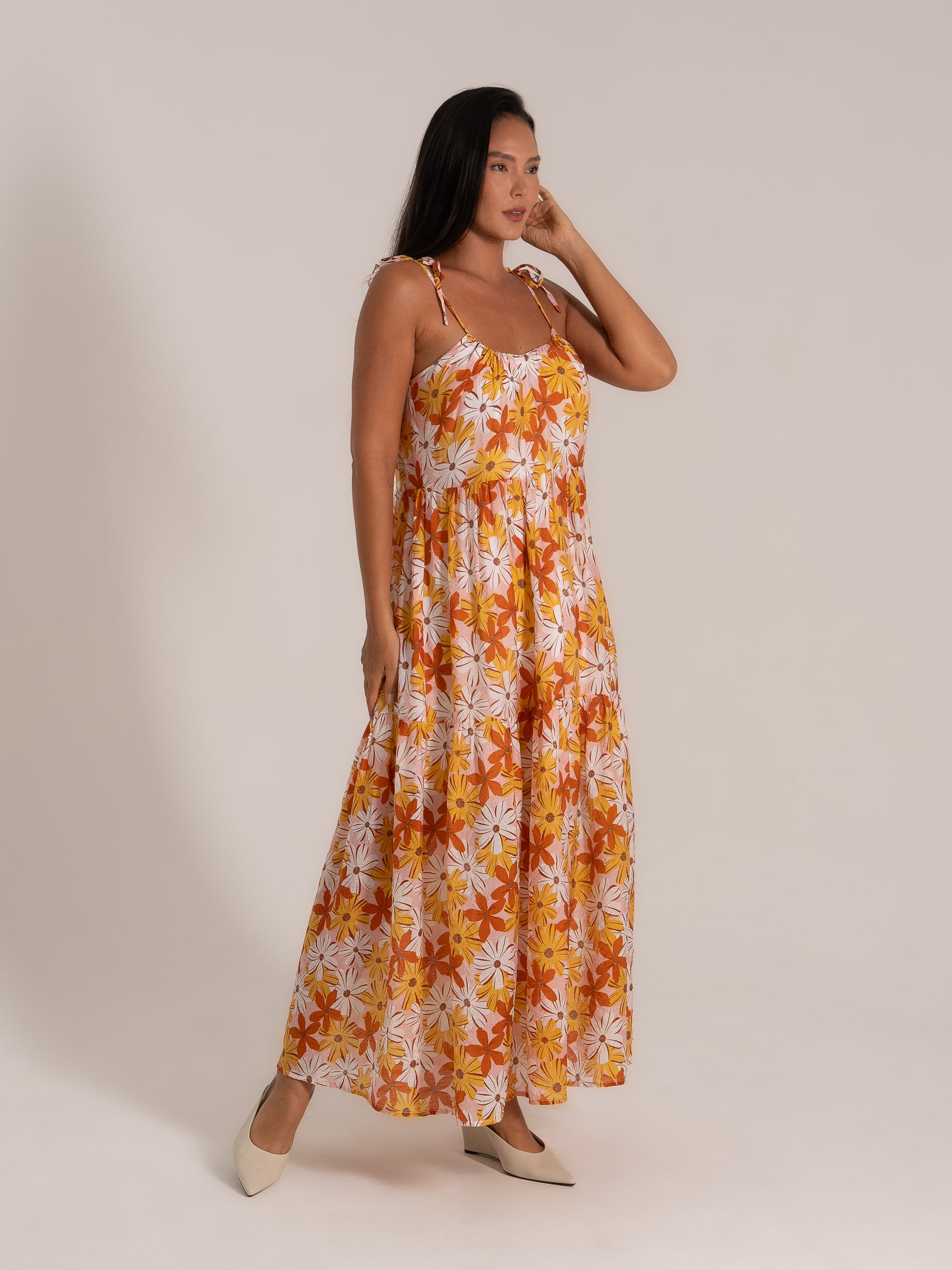 Side view of tiered floral maxi dress with pockets and tie straps