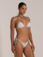 Side profile of silver halter bikini top with glittery fabric finish