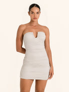 Front view of silver strapless mini dress with ruched detailing and sweetheart neckline