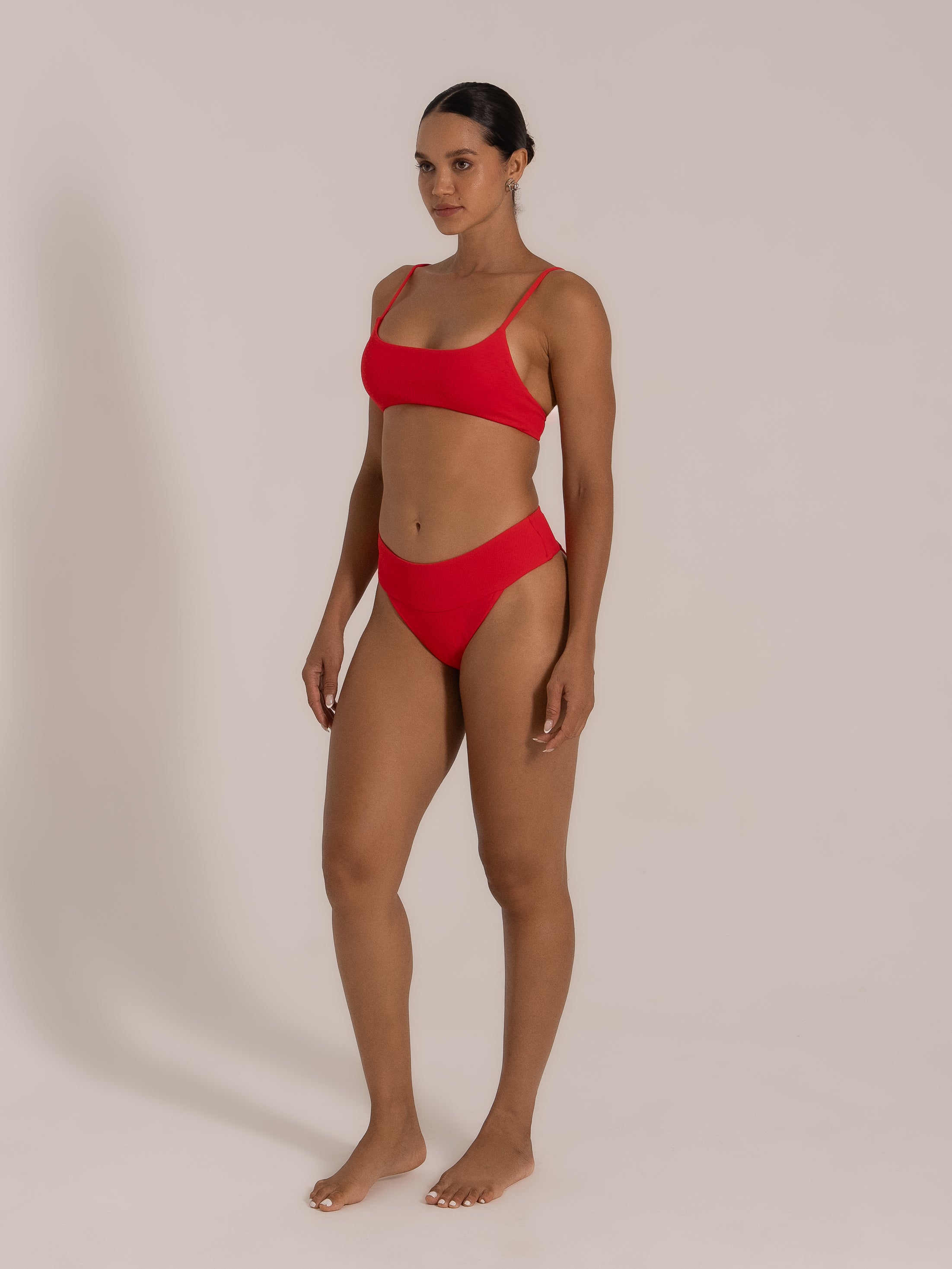 Front-facing model in red square-neck bikini set with sleek modern lines.