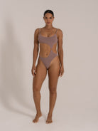 Front view of textured taupe one-piece swimsuit with side cutouts and ring detailing