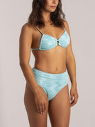 Woman wearing a textured light blue bikini set with front cutout detail and high-waisted bottom – front view