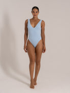 Baby blue textured one-piece swimsuit with deep neckline, shown from front-side view.