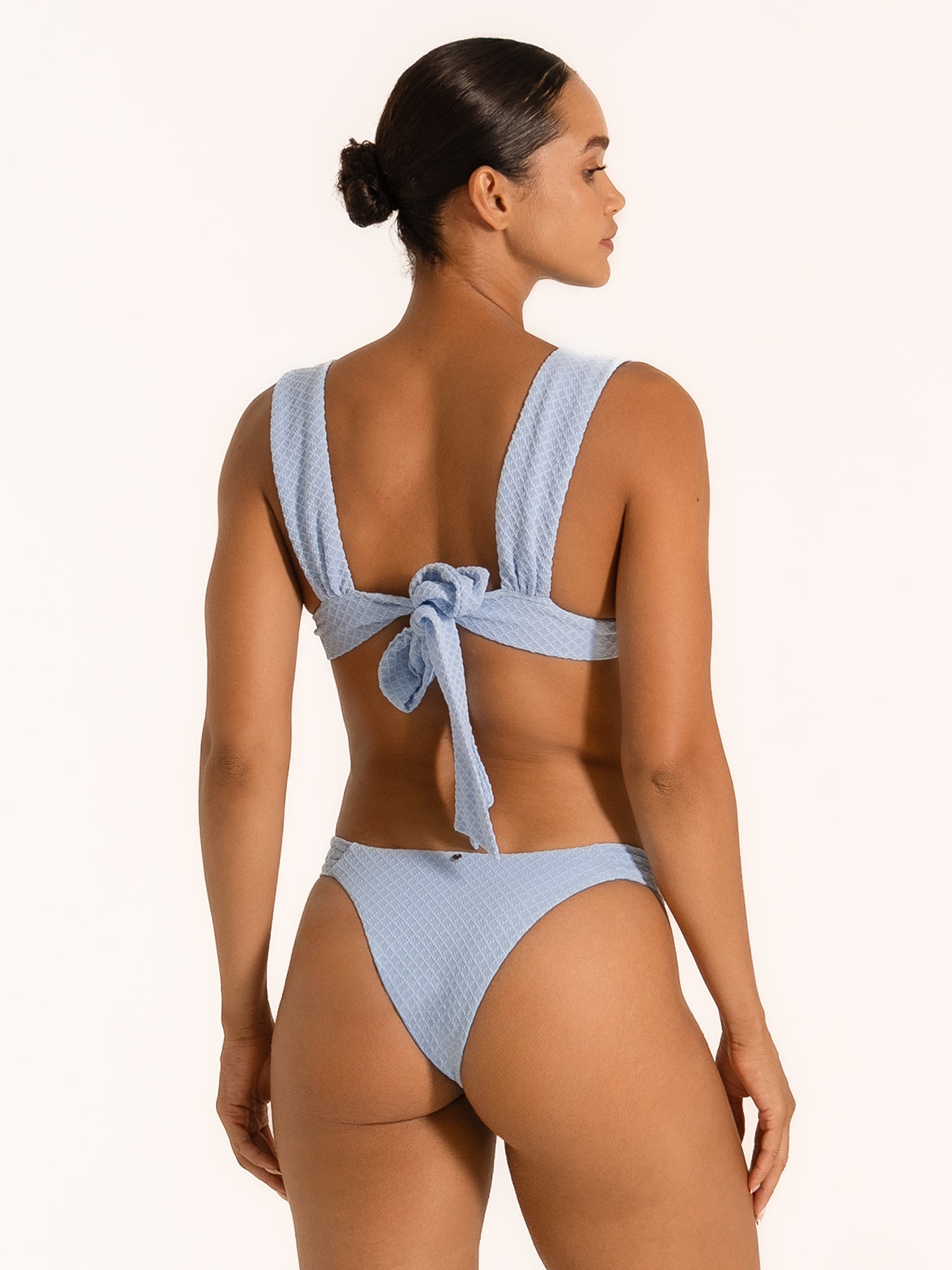 Back view of textured baby blue bikini with thick shoulder straps and large bow tie