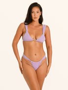 Full front view of woman wearing lilac textured bikini bottom with V-cut high leg design.