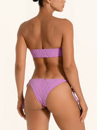 Back view of purple tie side bikini bottom with cheeky thong cut and ruched detail.