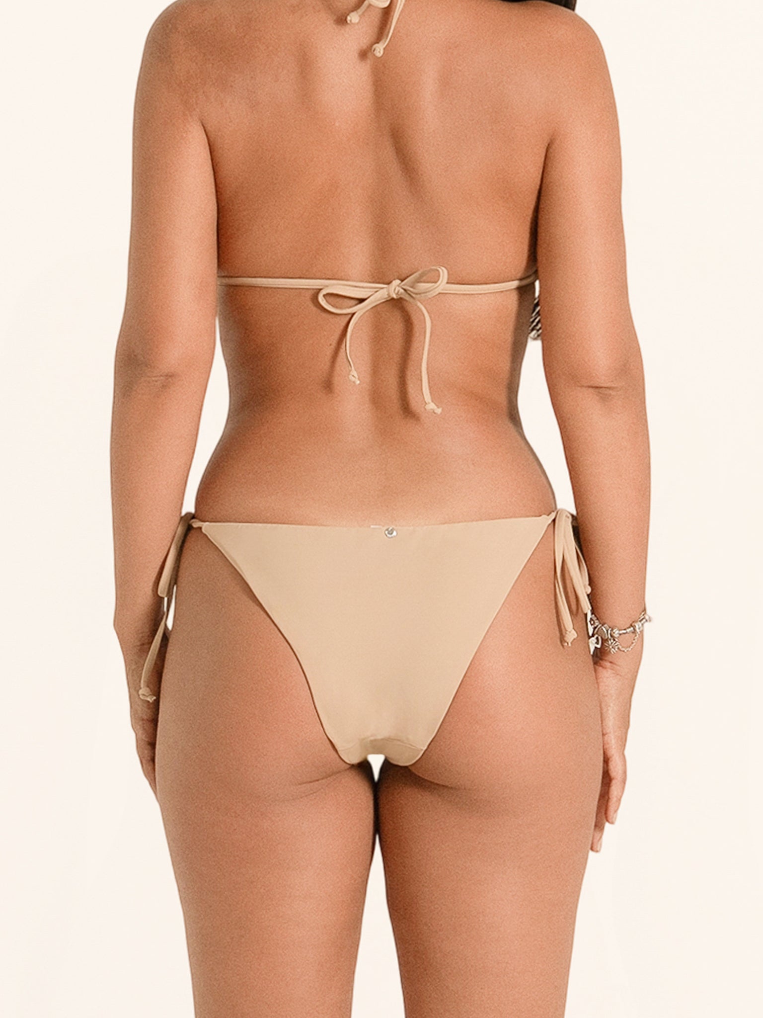 Classic beige bikini bottom featuring tie side design for custom fit.
