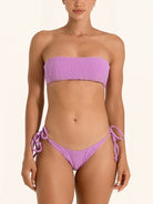 Front view of purple tie side bikini bottom styled with matching bandeau bikini top.