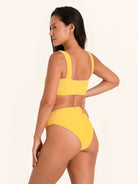 Trendy mustard yellow bikini bottom with thick waistband and sculpting effect.