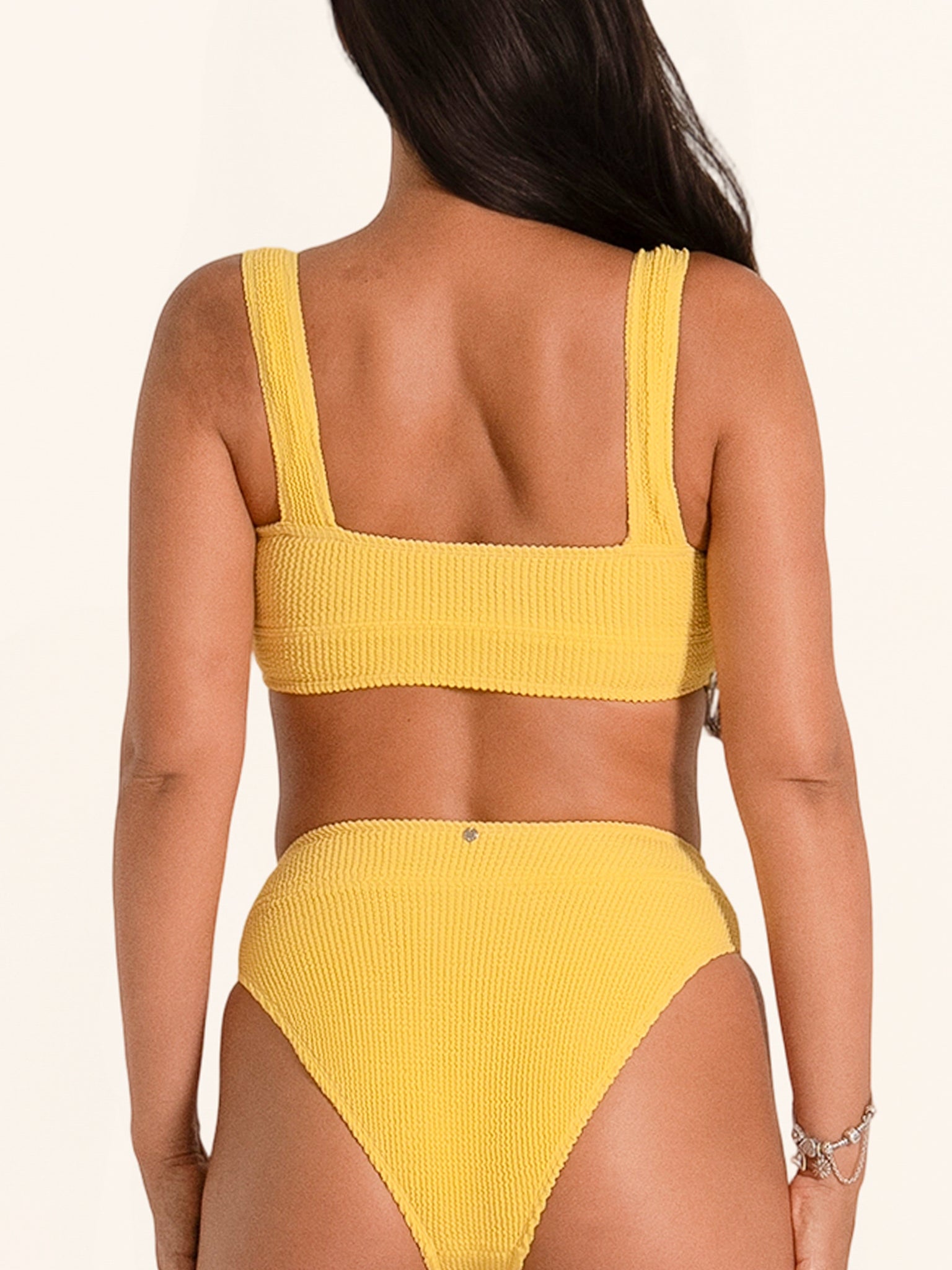 Trendy bikini top in mustard yellow with square neck and thick strap design.