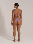 Back view of woman wearing twist front bandeau bikini set in purple
