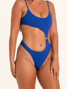 Side angle of blue textured cut out one piece swimsuit with high leg cut and waist cutouts.