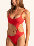 Side angle of red textured cut out one piece swimsuit featuring waist cutout and ring accent.