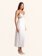 Side profile of white cut out midi dress with fitted waist