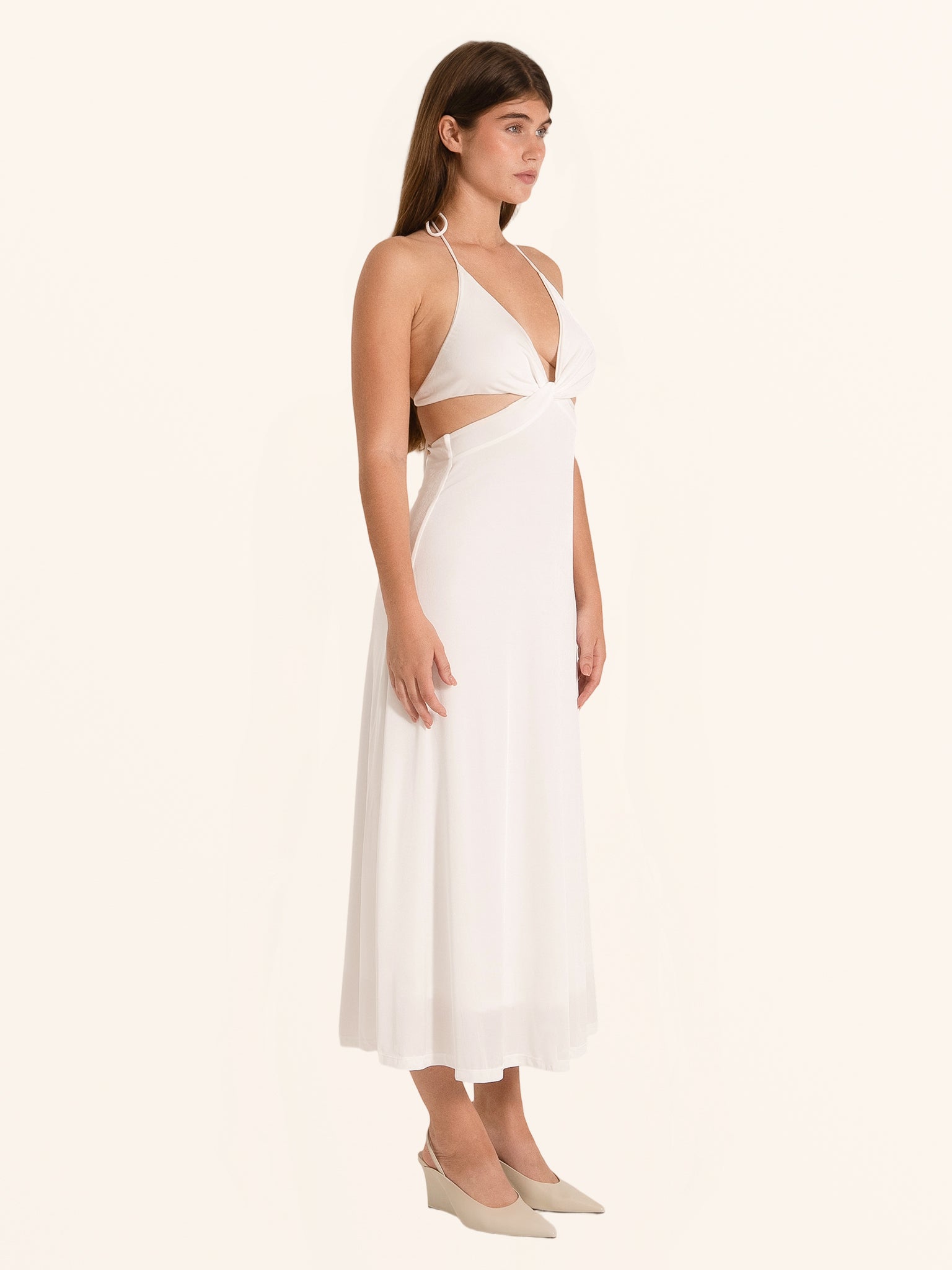 Side angle of white cut out maxi dress with flowing hemline