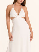 Side profile of white cut out maxi dress with halter neckline