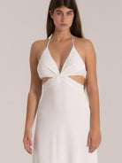 Front view of a white halter dress featuring front twist detail and side cutouts, ideal for summer resort wear.