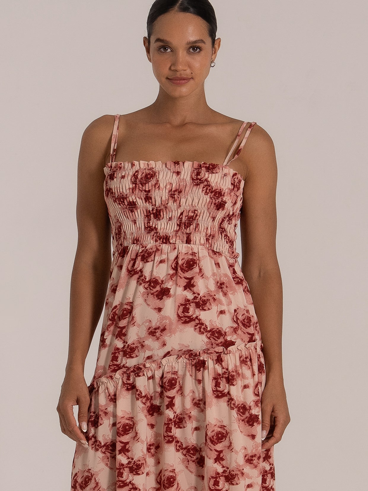 Front view of a white maxi dress featuring side cutouts, twisted bust, and delicate spaghetti straps
