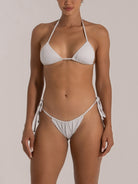 Front view of woman in sparkly white triangle bikini with adjustable halter neck and side tie bottom