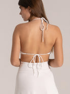 Back view of a white halter dress with adjustable ties and open back design, perfect for beach holidays.