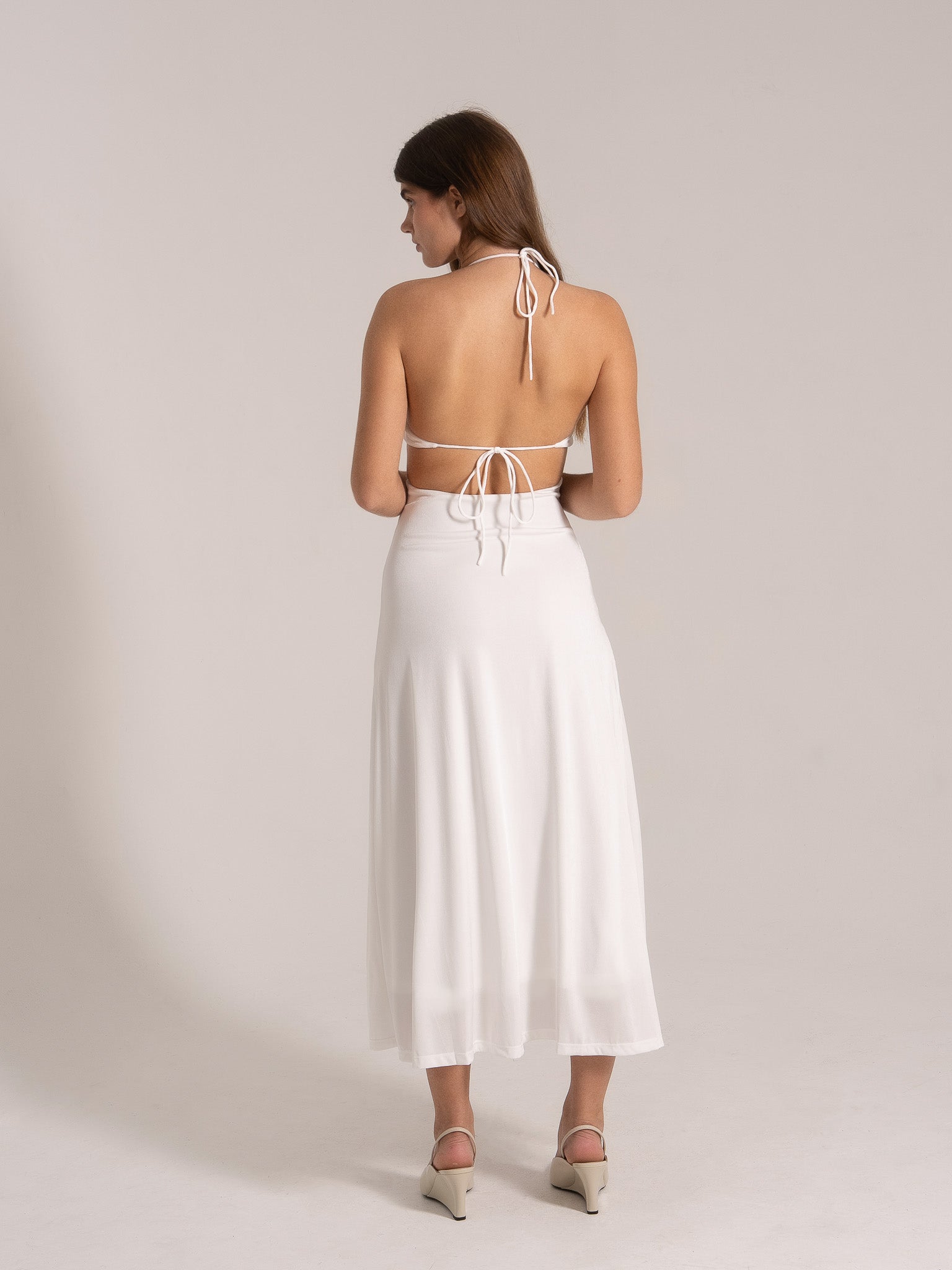 Back view of open-back halter maxi dress with tie straps in white
