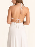 Back view of white halter maxi dress with open back and tie straps