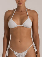 Front close-up view of a white halter triangle bikini top and matching tie-side bikini bottom with shimmer fabric.
