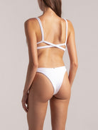 Back view of a white high-leg textured bikini bottom with wide waistband on model