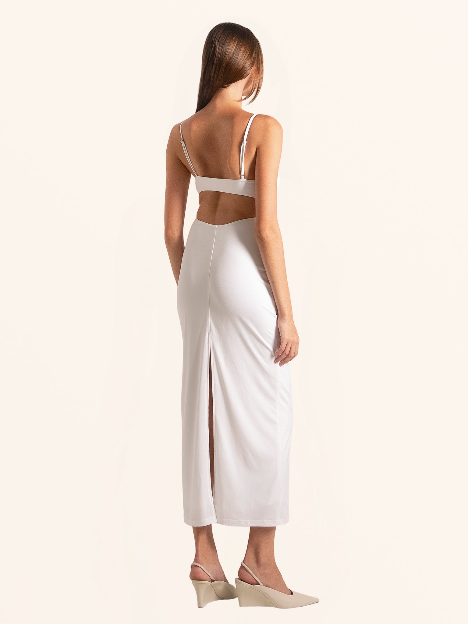 Back view of white midi dress with thin straps and cut out