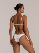Woman wearing a white ribbed triangle bikini set with side tie bottom, back view