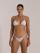 Front view of a woman in a white tie-side shimmer bikini set.