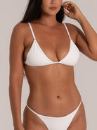 Close-up of model wearing white textured triangle bikini with adjustable straps and minimal coverage for a sleek, modern swimwear look.