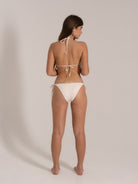 Back view of model wearing white bikini with side tie bottoms